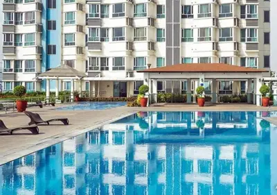 a swimming pool in front of a large building at Cobblestone City Stays - SM Mezza 1 Residences in Manila