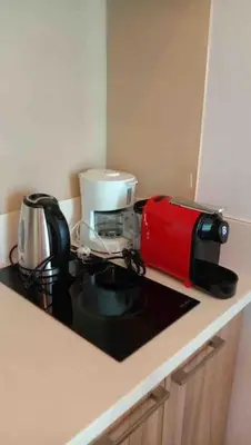 a kitchen counter with a coffee maker and a coffeemaker at Modern 1BD in Ortigas, WiFi ,Netflix ,Pool ,Gym in Manila