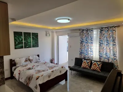 a bedroom with a bed and a couch in it at 1 MARY's STAYCATION Condo Type with Balcony 2 person in Tanza