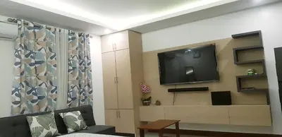 a living room with a flat screen tv on a wall at 1 MARY's STAYCATION Condo Type with Balcony 2 person in Tanza