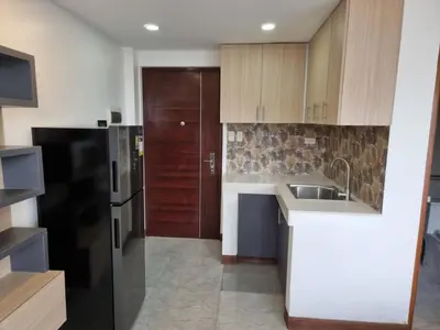 a kitchen with a sink and a black refrigerator at 1 MARY's STAYCATION Condo Type with Balcony 2 person in Tanza