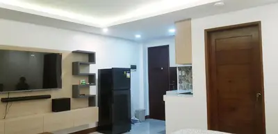 a kitchen with a television and a black refrigerator at 1 MARY's STAYCATION Condo Type with Balcony 2 person in Tanza