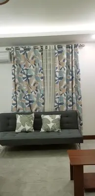 a couch sitting in a living room with curtains at 1 MARY's STAYCATION Condo Type with Balcony 2 person in Tanza