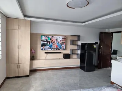 a living room with a tv and a black refrigerator at 1 MARY's STAYCATION Condo Type with Balcony 2 person in Tanza