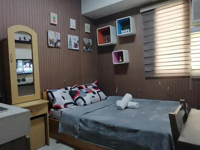 a bedroom with a bed and a mirror and a television at pierrecondotel in Manila