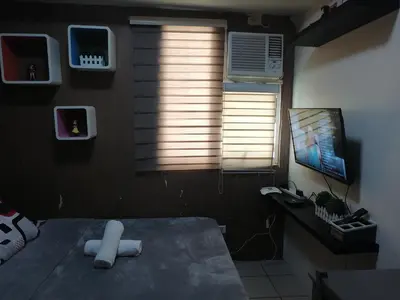 a room with a bed and a tv and a window at pierrecondotel in Manila