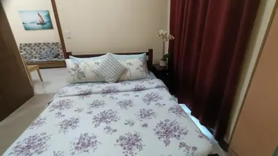 a bedroom with a bed with a purple and white comforter at 1 bedroom Condotel in front of terminal 3 Airport in Manila