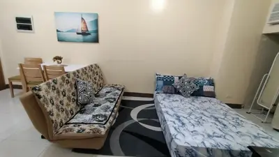 a living room with two beds and a couch at 1 bedroom Condotel in front of terminal 3 Airport in Manila