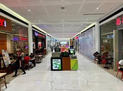 a shopping mall with people sitting at tables in it at Belle 4621 by TPS in Manila