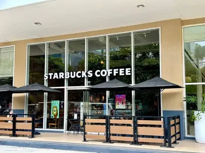 a starbucks coffee store with umbrellas in front of it at Belle 4621 by TPS in Manila