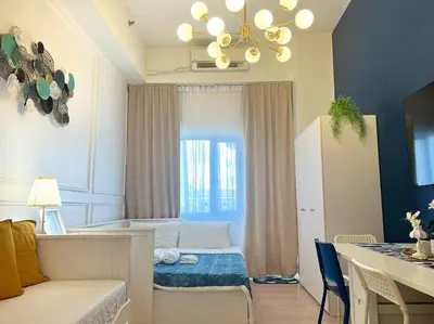 a living room with a bed and a dining table at Belle 4621 by TPS in Manila