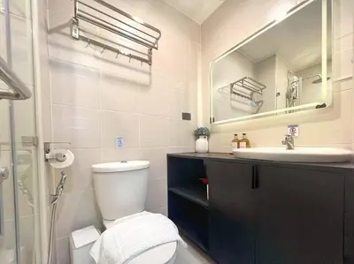 a bathroom with a toilet and a sink and a mirror at Belle 4621 by TPS in Manila