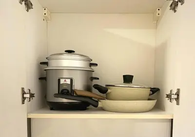 a kitchen shelf with a slow cooker and other kitchen utensils at Belle 4621 by TPS in Manila
