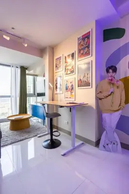 a woman standing next to a table in a room at Korea In The City Staycation with Pool, Gym and More in Manila
