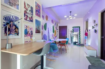 a room with a table and chairs and posters on the walls at Korea In The City Staycation with Pool, Gym and More in Manila