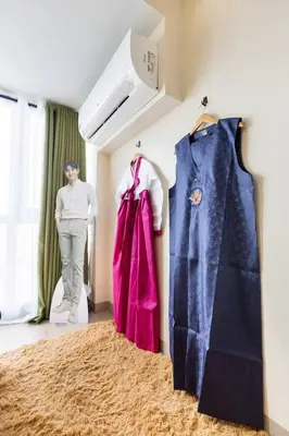 a man standing in a room next to two shirts at Korea In The City Staycation with Pool, Gym and More in Manila