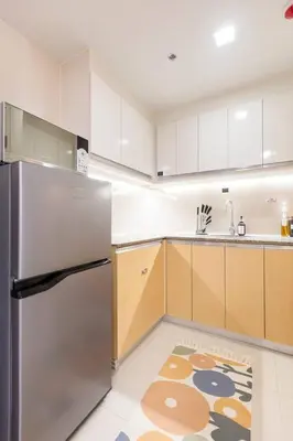 a kitchen with a stainless steel refrigerator and a rug at Korea In The City Staycation with Pool, Gym and More in Manila