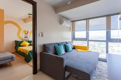 a room with a mirror and a couch and a bed at Korea In The City Staycation with Pool, Gym and More in Manila