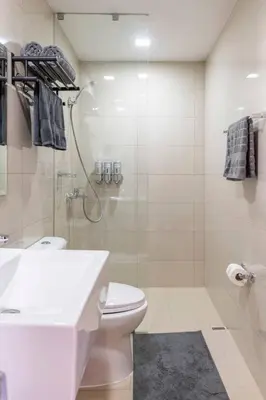 a bathroom with a shower and a toilet and a sink at The Peaky Blinder s Crib with Gym, Pool, Sauna More in Manila