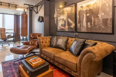 a living room with a brown leather couch and chairs at The Peaky Blinder s Crib with Gym, Pool, Sauna More in Manila