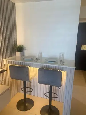 a bar with two stools in front of a counter at B & M Condo near NAIA Airport and SM Mall in Manila