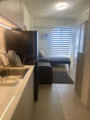 a kitchen with a sink and a couch in a room at B & M Condo near NAIA Airport and SM Mall in Manila