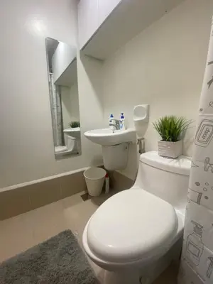 a white bathroom with a toilet and a sink at B & M Condo near NAIA Airport and SM Mall in Manila