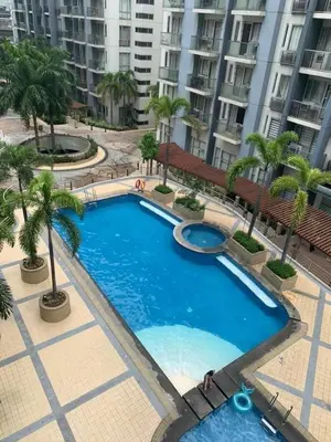 a large swimming pool with palm trees and buildings at vevilyn condotel in Manila
