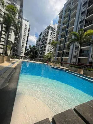 a large blue swimming pool in front of some buildings at vevilyn condotel in Manila