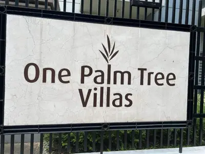 a sign that reads one palm tree villas on a fence at vevilyn condotel in Manila