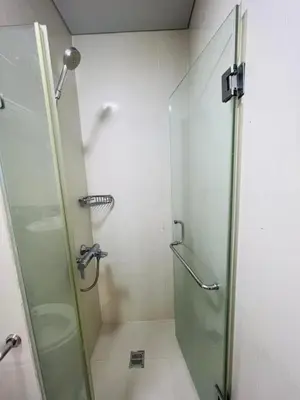 a bathroom with a shower with a glass door at vevilyn condotel in Manila