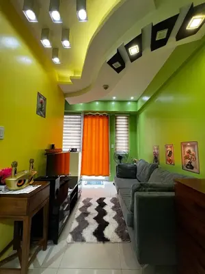 a living room with green walls and a couch at vevilyn condotel in Manila