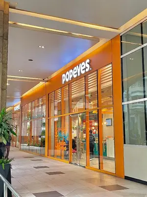a store front of a poeyes store with its doors open at 101 Newport Blvd - SkyStag Aerie near NAIA T3 in Manila