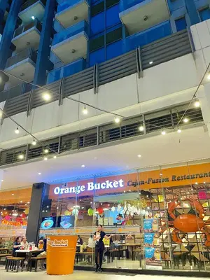 an orange bucket restaurant in a building with people in it at 101 Newport Blvd - SkyStag Aerie near NAIA T3 in Manila
