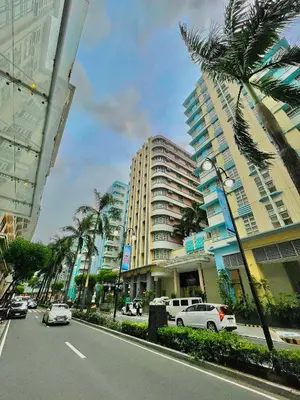 a city street with palm trees and buildings at 101 Newport Blvd - SkyStag Aerie near NAIA T3 in Manila