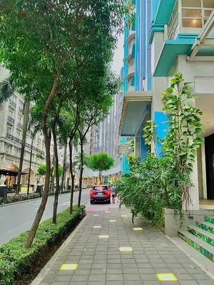 a car is driving down a city street with trees at 101 Newport Blvd - SkyStag Aerie near NAIA T3 in Manila