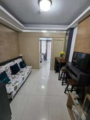 a living room with a bed and a piano at Moa Staycation at Sea Residences Mingchie place in Manila
