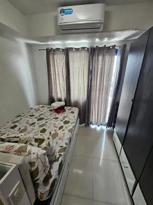 a small bedroom with a bed and a air conditioner at Moa Staycation at Sea Residences Mingchie place in Manila