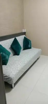 a bed with two green pillows on top of it at Moa Staycation at Sea Residences Mingchie place in Manila
