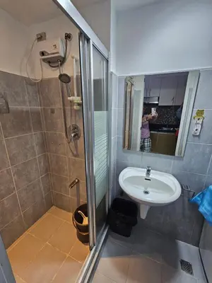 a woman taking a picture of a bathroom with a sink at Moa Staycation at Sea Residences Mingchie place in Manila