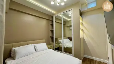 a small bedroom with a bed and a mirror at Kize Staycation in Manila