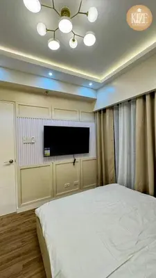 a bedroom with a bed and a flat screen tv at Kize Staycation in Manila