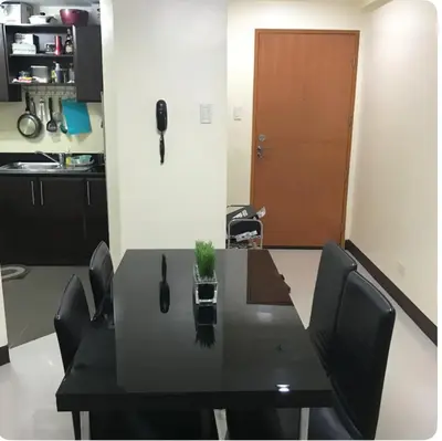 a black table with black chairs and a brown door at Montecito unit near airport in Manila