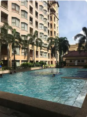 a swimming pool in front of a large building at Montecito unit near airport in Manila