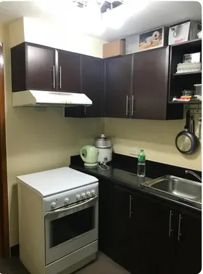 a small kitchen with a stove and a sink at Montecito unit near airport in Manila