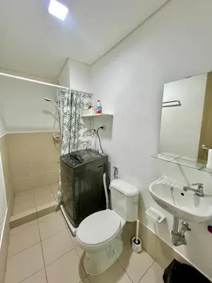 a white bathroom with a toilet and a sink at Glade Suite in Trece Martires