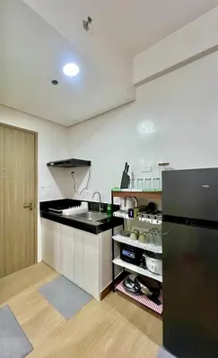 a kitchen with a sink and a black refrigerator at Glade Suite in Trece Martires