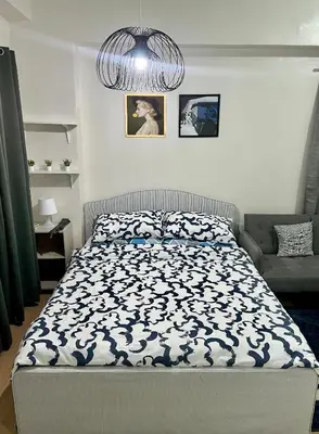 a bedroom with a bed and a chandelier at Glade Suite in Trece Martires