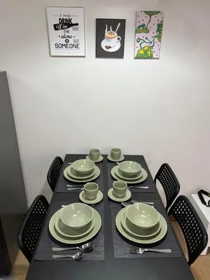 a table with plates and cups and utensils on it at Glade Suite in Trece Martires