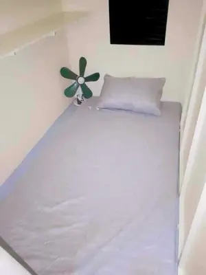 a white bed with a flower on the wall at RDC- Baclaran Transient Capsule in Manila
